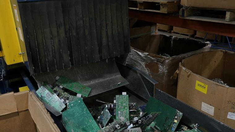 Circuit boards dropping off a conveyor into boxes