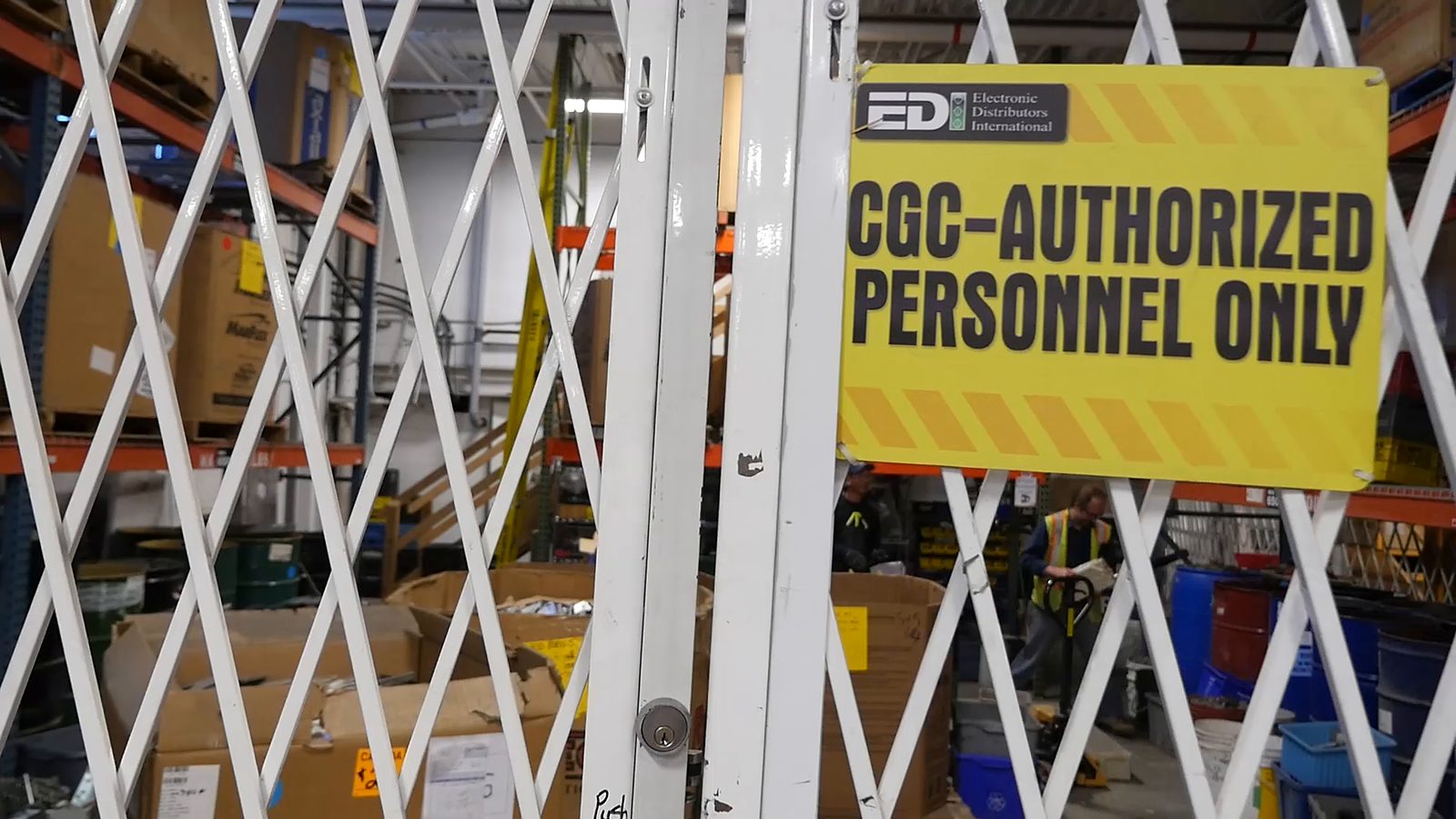A sign reading CGC-authorized personnel only on the gate of a locked cage
