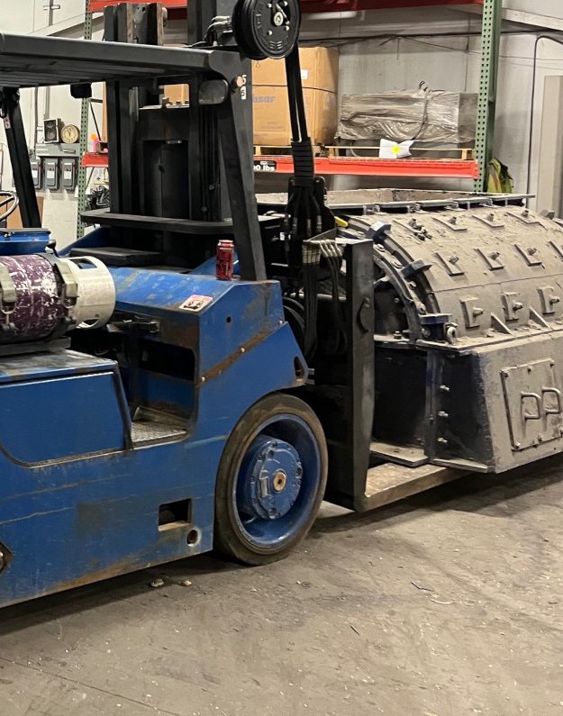 The chain mill on the forks of the blue counterbalance lift truck
