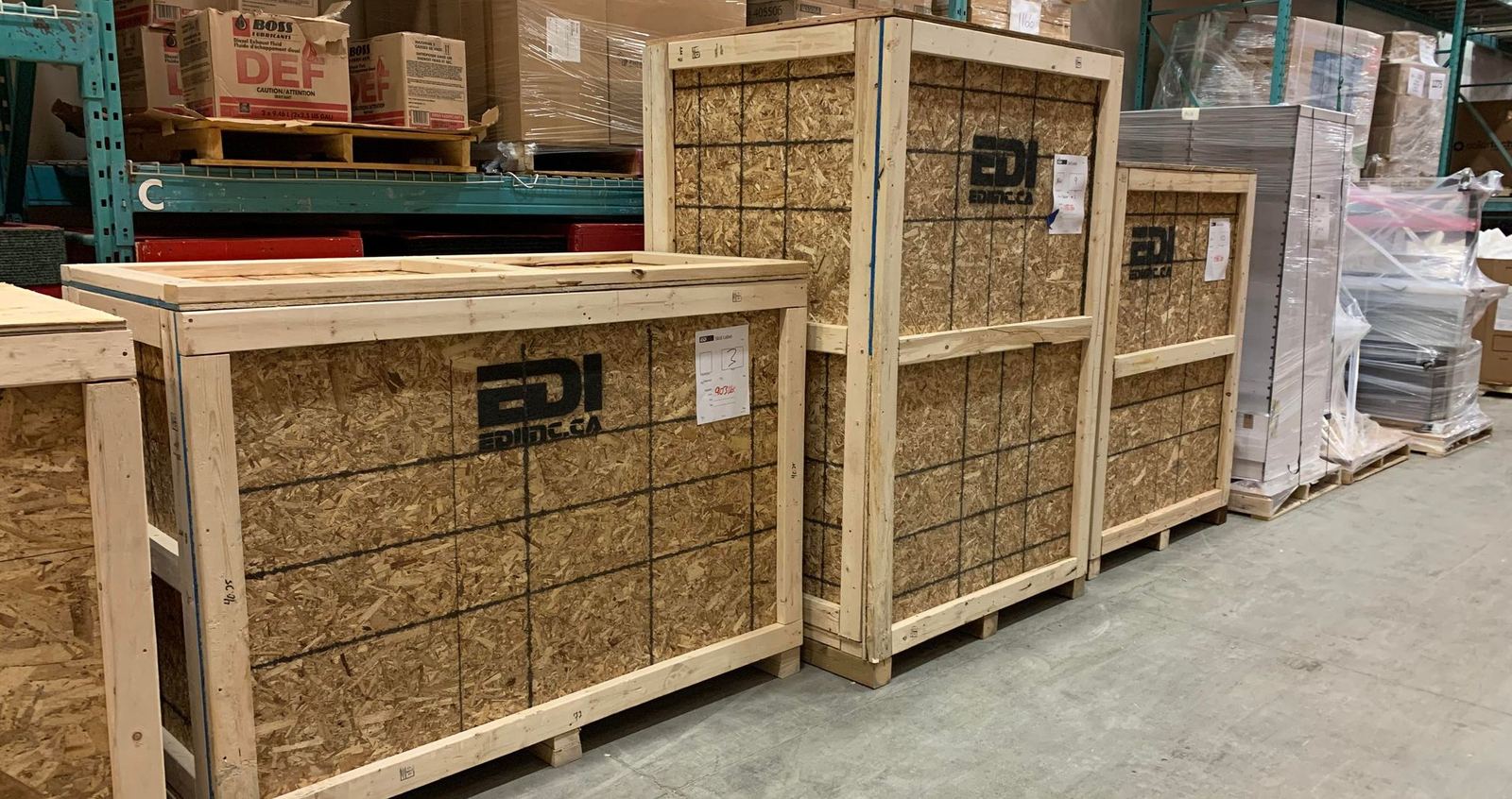 Wooden shipping crates stencilled with the EDI name, in a warehouse