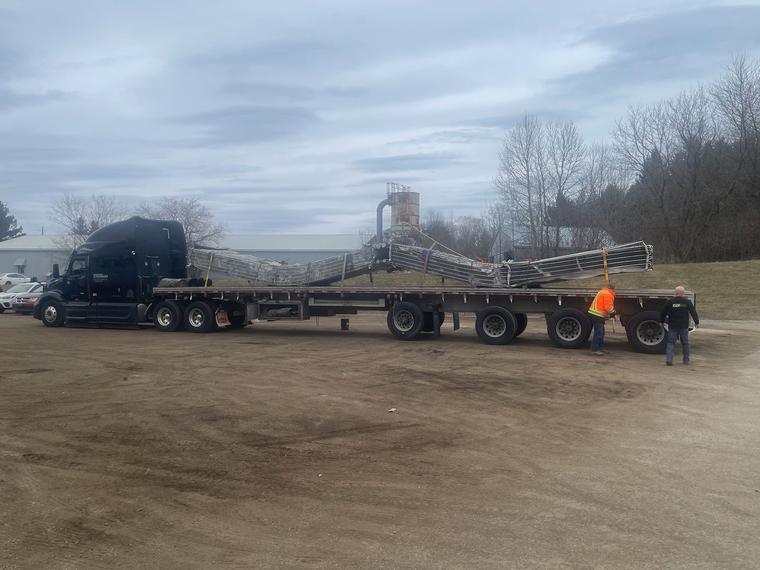 A flatbed truck loaded with rooftop condenser coils