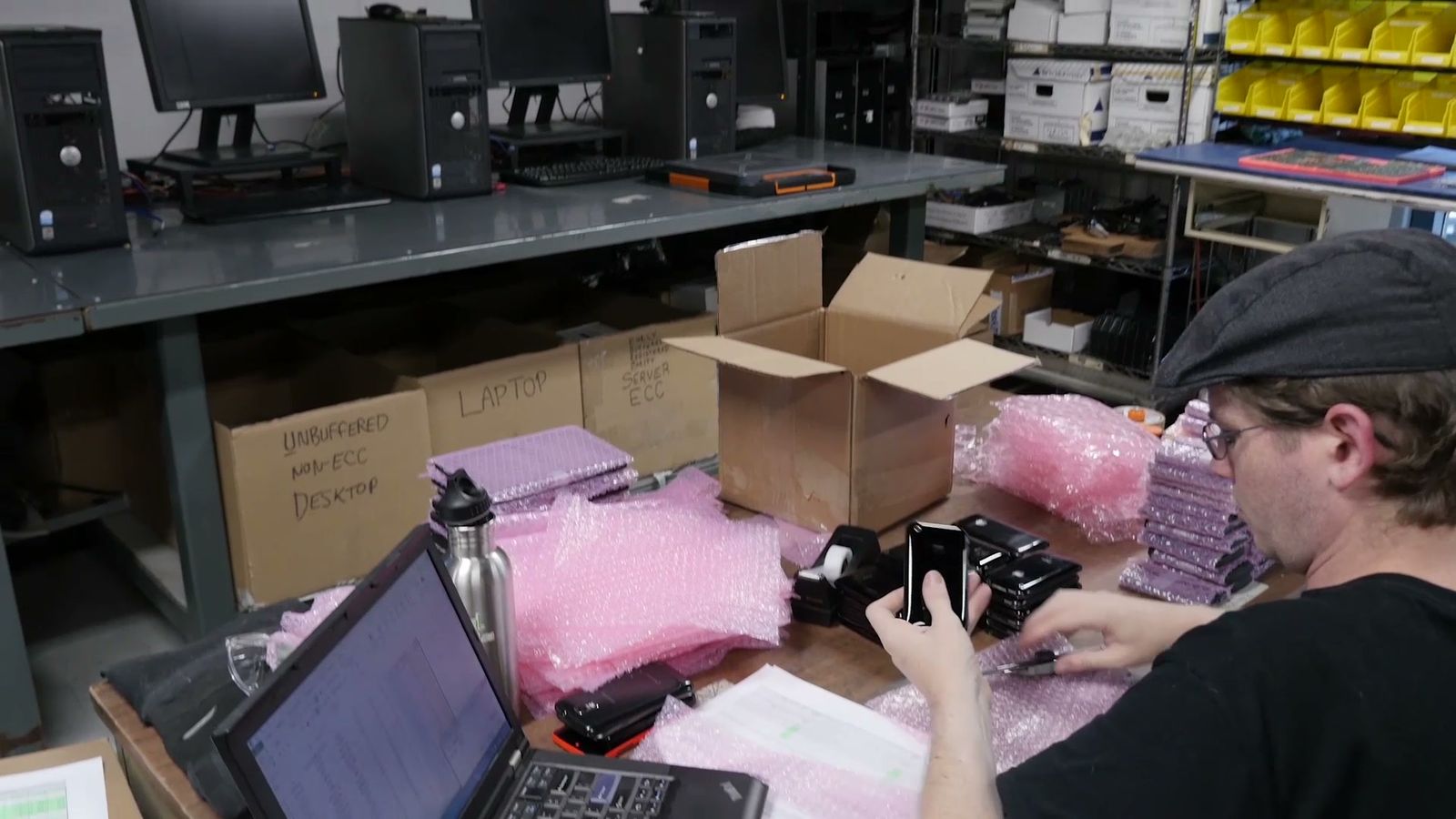A technician checking and packing tested equipment