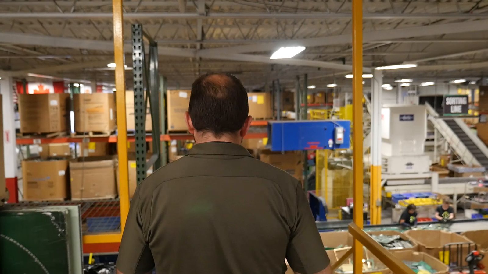 A man walking through the plant, seen from behind