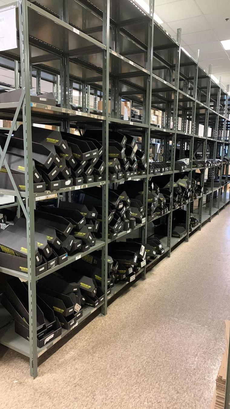 Steel storage shelving, built and loaded, in a stock room