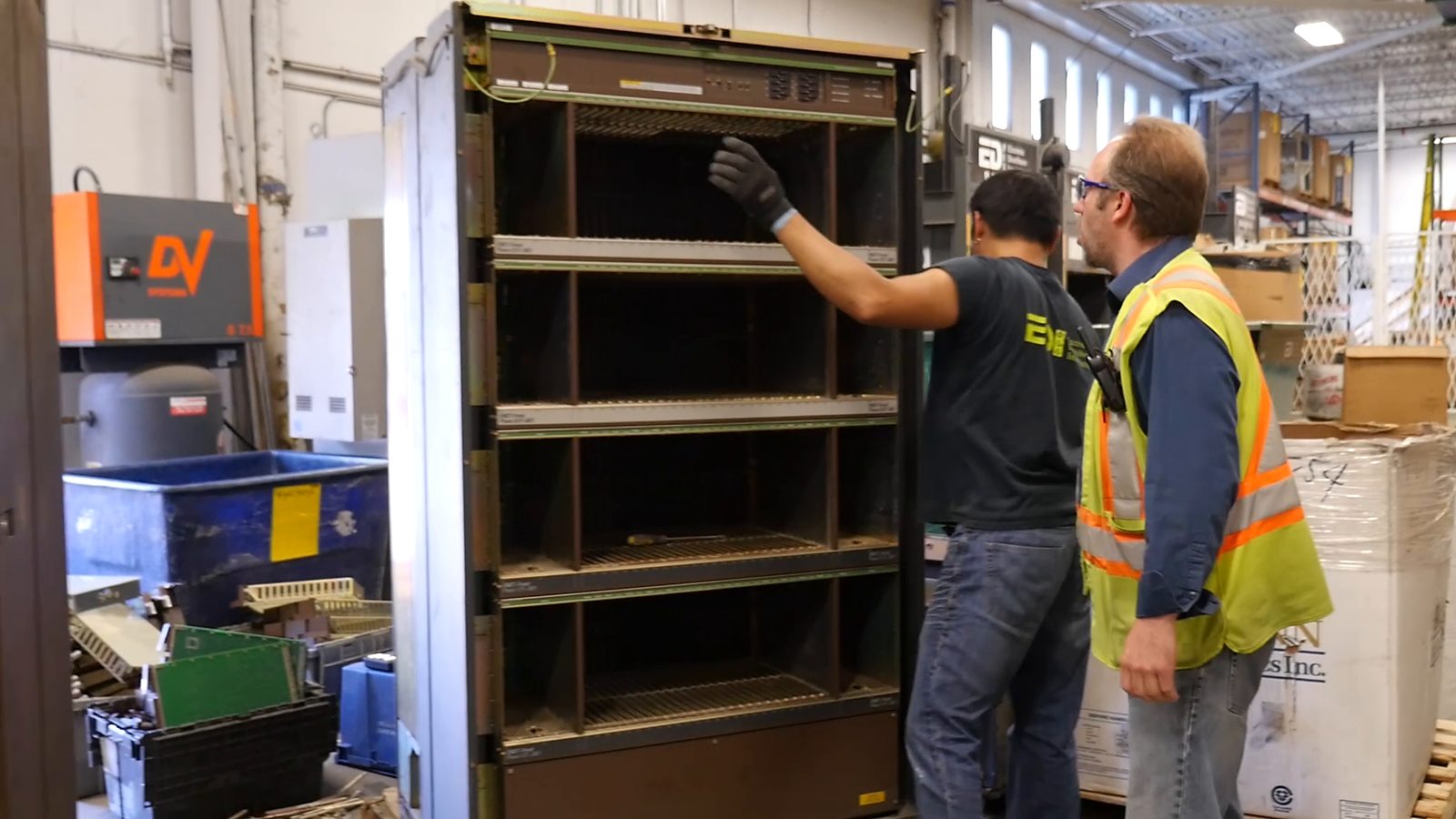Two EDI staff taking apart a large equipment cabinet