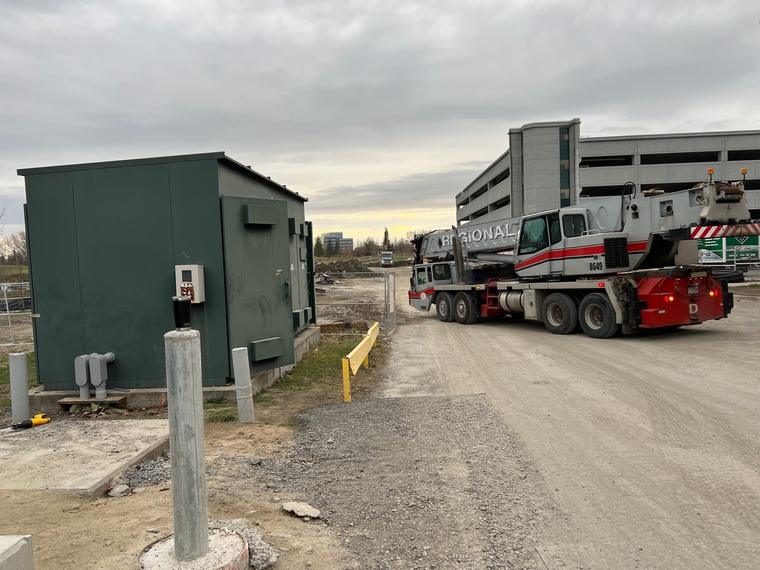 A transformer on the ground beside a crane truck